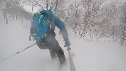 POV of young man skier skiing on a mountain during snow storm.