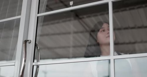 Woman hanging open sign on glass door