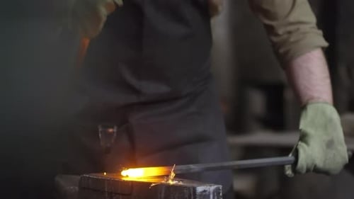 Blacksmith Forging Hot Metal With Hammer on Anvil