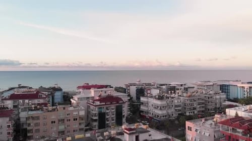 Urban city on coastline. Aerial drone view of picturesque city with calm sea water surface.