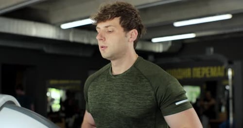 Fitness Man Training Cardio Exercise on Running Machine in Gym