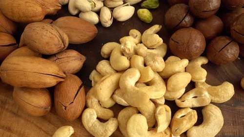 Assorted nuts on a wooden board.