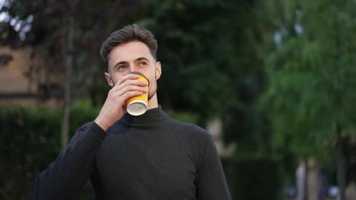 Smiling Handsome Man Drinking Morning Coffee Walking on Sunny City Street Leaving