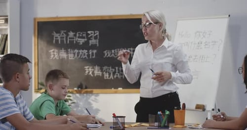 Teacher Explaining To Pupils in a Chinese Language Class