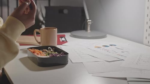 Woman Eating and Working at Night Office