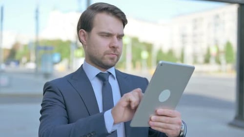 Man In Suit Using Tablet Outside