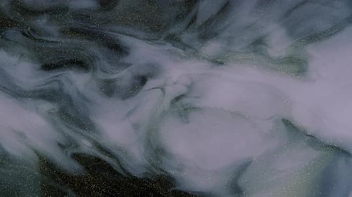 Wunderschöne golden schimmernde Partikel in weißem Rauch auf schwarzem Hintergrund