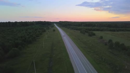 Top View of Car Driving Along Forest Highway at Dawn