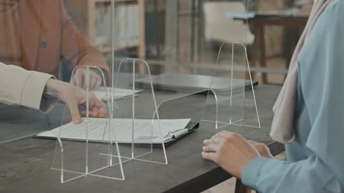 People Working in Office Behind Acrylic Safety Partition
