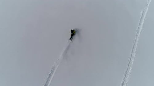 Snowmobile Adventure Across Snowy Mountain Landscape, Aerial View