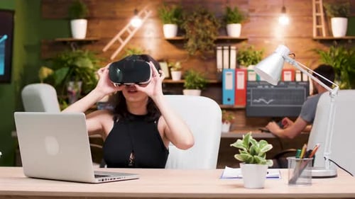 Woman Wearing VR Headset at Desk in Office