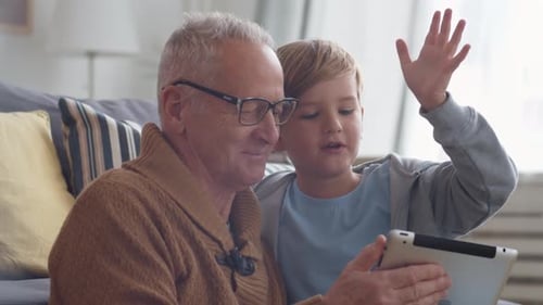 Grandfather and Grandson Using Tablet Indoors