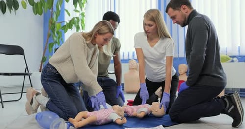 Adults Practice Infant CPR in Medical Training Class