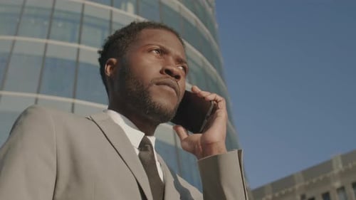 Businessman Talking on Phone in City, Low Angle
