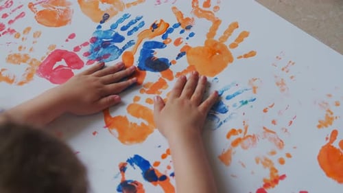 Child Creates Colorful Handprint Art at Home
