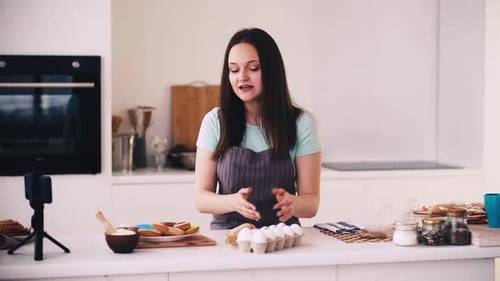 Woman Filming Baking Tutorial in Bright Kitchen