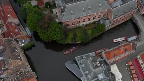 Canal with Boats Birds View in Bruges, Belgium Tilt Up To Reveal Cityscape