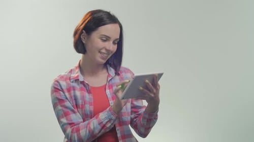 Smiling Woman Uses Tablet with Green Screen