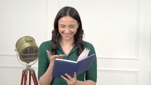 Indian girl reading funny comic book