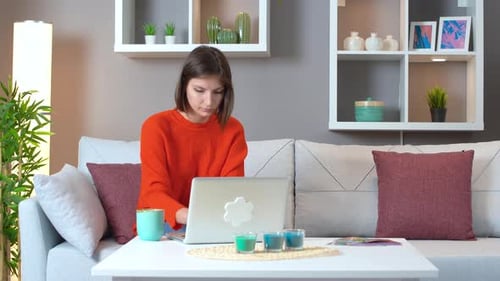 Woman Using Laptop While Sitting on Couch