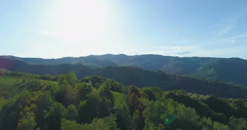 Beautiful Panoramic View of Forests, Green Hills and Mountains with Light Blue Sky