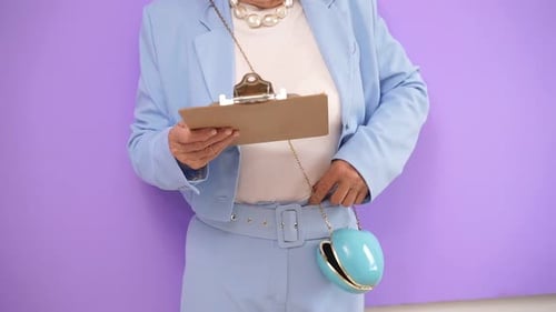 Senior Adult in Blue Suit Holding Clipboard