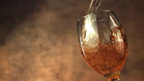 Golden Liquid Pouring Into Wine Glass Close-Up