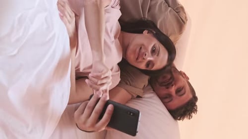 Paar benutzt Telefon im Bett