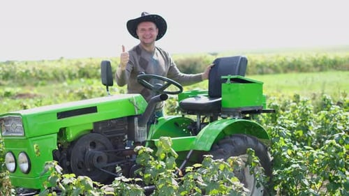 Farmer on Tractor Giving Thumbs Up in Field