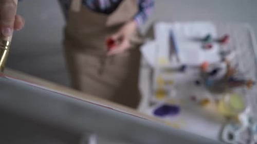 Painter Applying Red Color to Canvas With Brush