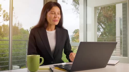 Frau arbeitet von zu Hause aus auf ihrem Laptop