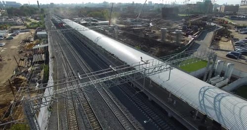 Electric Train Arriving To the Station in City Outskirts, Aerial View