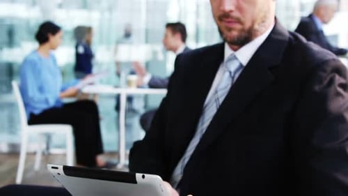 Man Uses Tablet in Modern Office Lobby