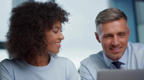 Colleagues Working Together on a Laptop in Office