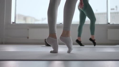 Nahaufnahme einer weiblichen Ballerina, die auf Socken ohne Spitzenschuhe läuft