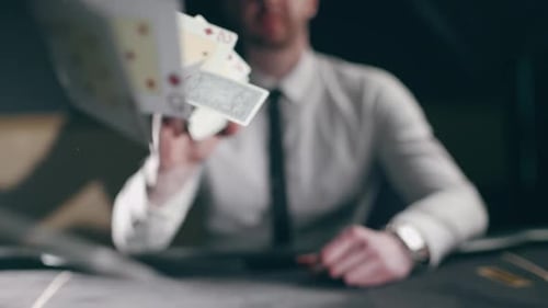 Cards Tossed by Man at Gaming Table