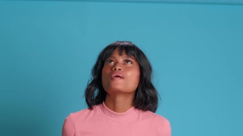 Junge dunkelhäutige Frau hebt den Kopf hoch und schreit freudig etwas