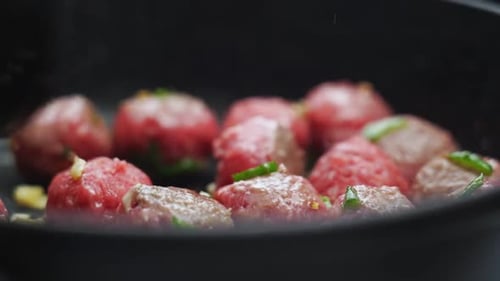 Unerkennbare Person kocht Fleischbällchen auf Bratpfanne mit Öl