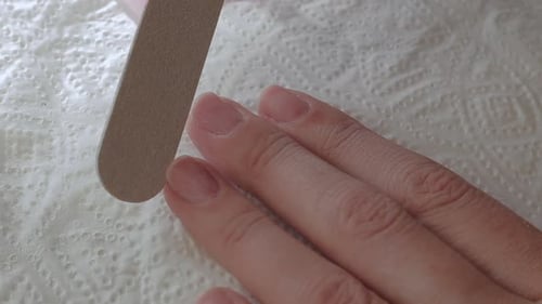 Close Up Woman Remove Old Gel From Nails with Nail File. Woman Getting Nail Manicure.