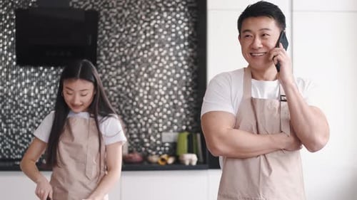 Man Talks on Phone as Girl Chops in Kitchen