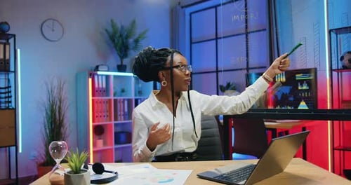 Woman Presenting Business Analytics on Glass Board