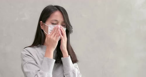 Woman Puts on and Adjusts Surgical Mask