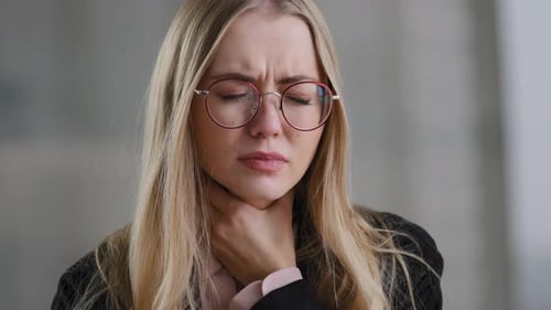 Femme d'affaires caucasienne fille dans des lunettes travailleur manager tenant la gorge à l'intérieur sent mal à l'inconfort