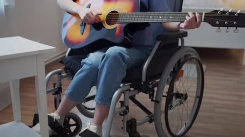 Woman Plays Guitar in Wheelchair and Sings