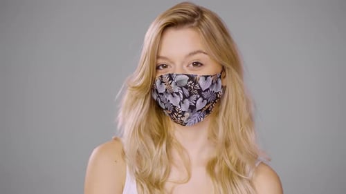 Content Woman Taking Off Mask and Looking at Camera