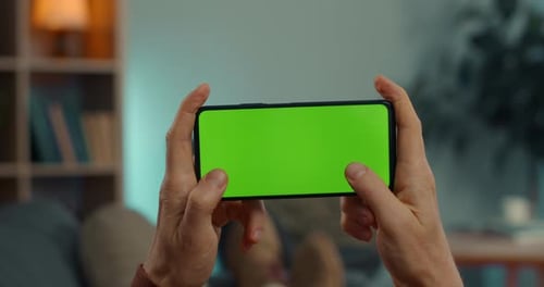 Man Using Smartphone with Chroma Key Screen at Home
