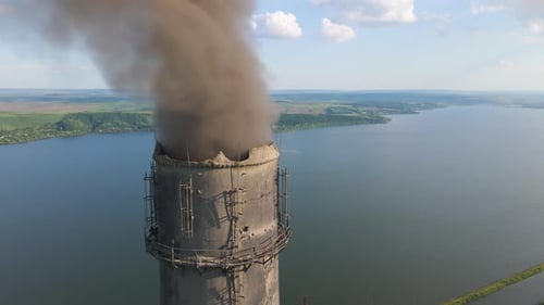 Aerial view of coal power plant high pipes with black smokestack polluting atmosphere.
