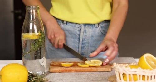 Young Adult Slices Lemon to Make Lemon Water