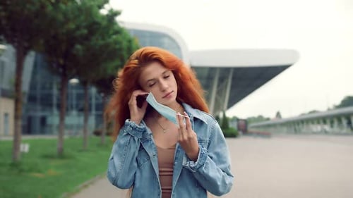 Young Woman Puts on a Medical Face Mask