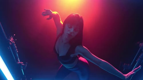 Portrait of Pretty Woman in Sexy Outfit Moves Her Flexible Arms in Studio